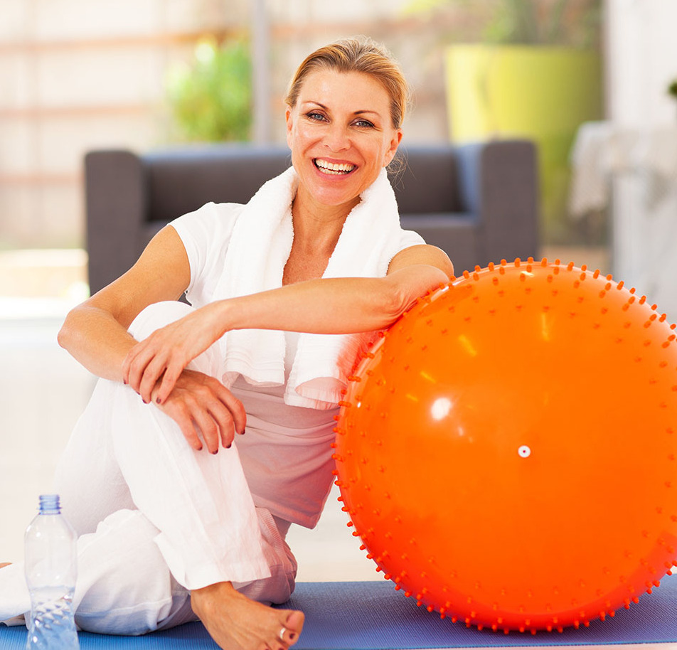 Smiling woman sitting on the floor during exercise session